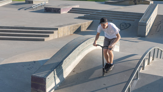 skater-riding-a-pro-scooter-at-a-skate-park